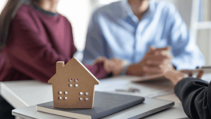 Model house on a notebook during a real estate investment consultation between investors and financial professionals 