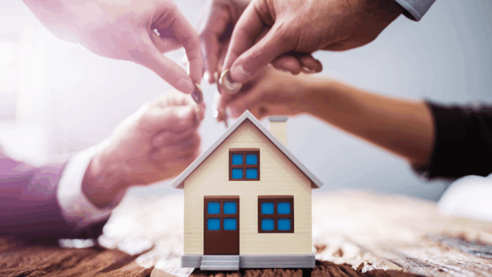 Multiple investors contributing funds around a model house, symbolizing passive real estate investing and shared property investment returns 