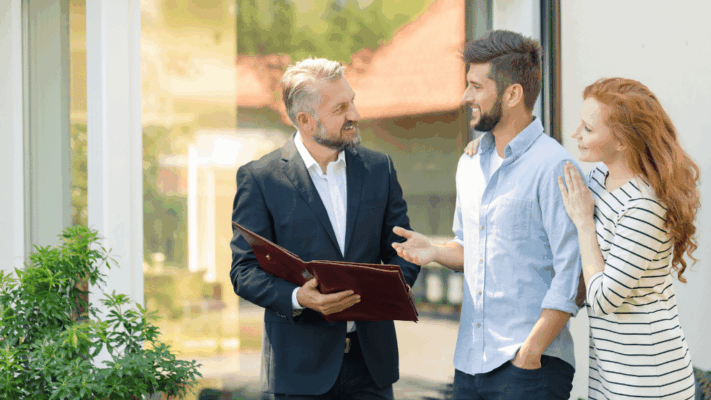 Real estate agent meeting with a young couple during a property consultation, discussing home buying opportunities and housing options. The image represents real estate services, property investment guidance, homeownership planning, client relationship management, residential property sales, mortgage consultation, real estate partnerships, and professional housing advisory services.