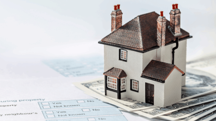 Model house placed on cash and property documents representing real estate portfolio growth, property investment, and financial planning 