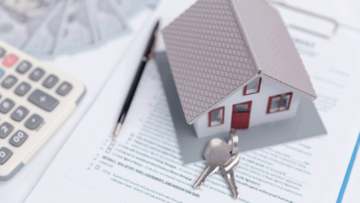 Model house, keys, calculator, and financial paperwork representing multifamily real estate syndication and property investment analysis 