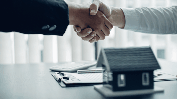 A professional real estate investment scene featuring a handshake between two parties with a model home and financial documents in the foreground, symbolizing trust, partnership, and aligned investment decisions. The image represents building a real estate investment strategy, passive multifamily investing, financial goal planning, long-term wealth creation, investor-sponsor partnerships, due diligence, portfolio diversification, disciplined investment decision-making, commercial real estate strategy, and aligning investment opportunities with long-term financial objectives.