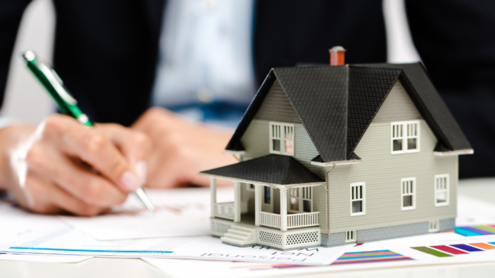 A model home sits in the foreground while an investor reviews documents and financial reports, representing the careful analysis required before committing to a multifamily investment. The image emphasizes evaluating a property's business plan, financial projections, and overall investment strategy, making it ideal for topics such as **evaluating multifamily business plans before you invest**, due diligence, multifamily investing, financial analysis, underwriting, investment strategy, commercial real estate, and long-term portfolio growth.
