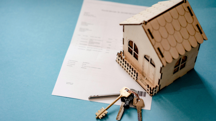A model house sits on top of a property-related document with a set of keys placed in the foreground, representing the connection between property ownership, documentation, and day-to-day operations. The image conveys the administrative and operational side of managing real estate assets, making it ideal for topics such as **how property management impacts syndication performance**, multifamily property management, operational efficiency, tenant management, lease administration, property operations, asset management, investor returns, occupancy performance, maintenance coordination, and maximizing long-term syndication success.
